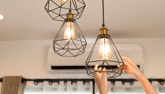 Landlord updating a kitchen light fixture to improve property appeal, a simple upgrade highlighted in rental marketing tips.